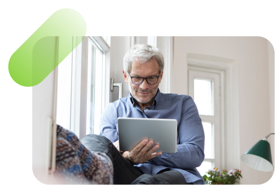 Person sitting on a couch playing on a tablet.